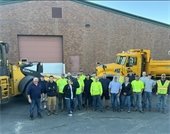 public works team standing in a group by trucks outside of office