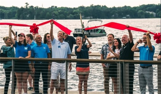 the mayor and council cutting a red ribbon on the lakewalk on the water