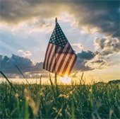 an american flagged stacked into grass