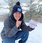 public works staff holding medallion in the snow