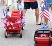 two men pulling wagons decorating with the american flag