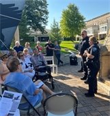 police chief and deputy police chief talking to people at a night to unite party outside