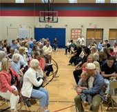 people sitting in a gym for a meeting
