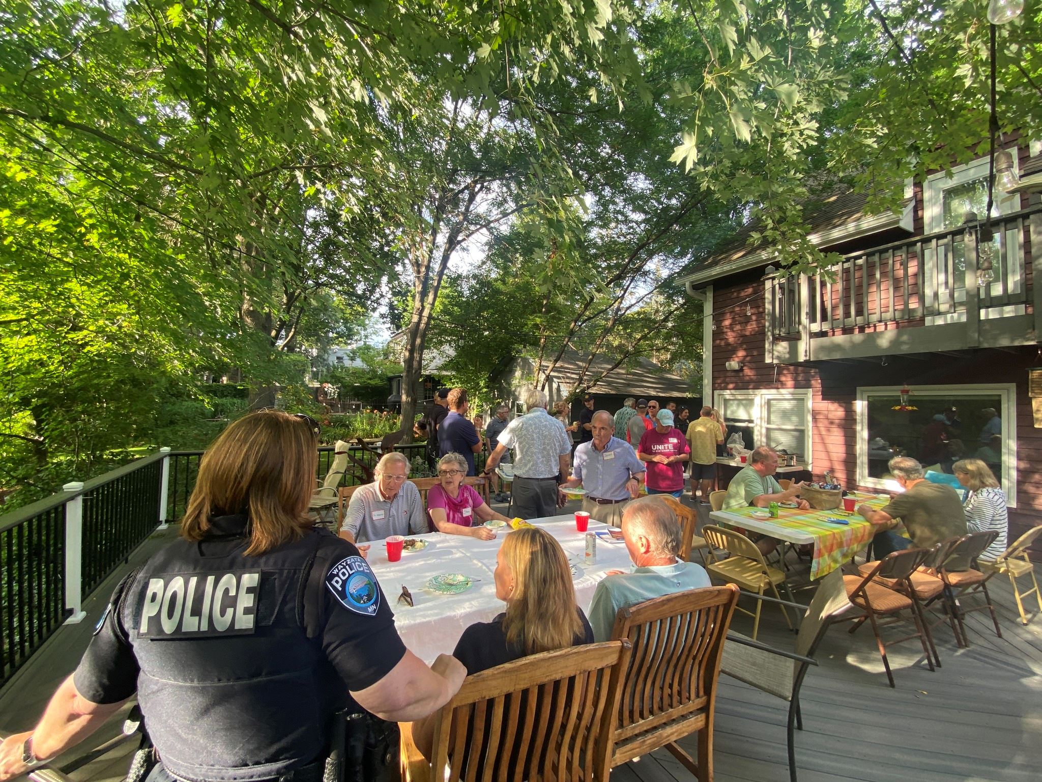 police chief on a neighbors deck talking to a group on night to unite