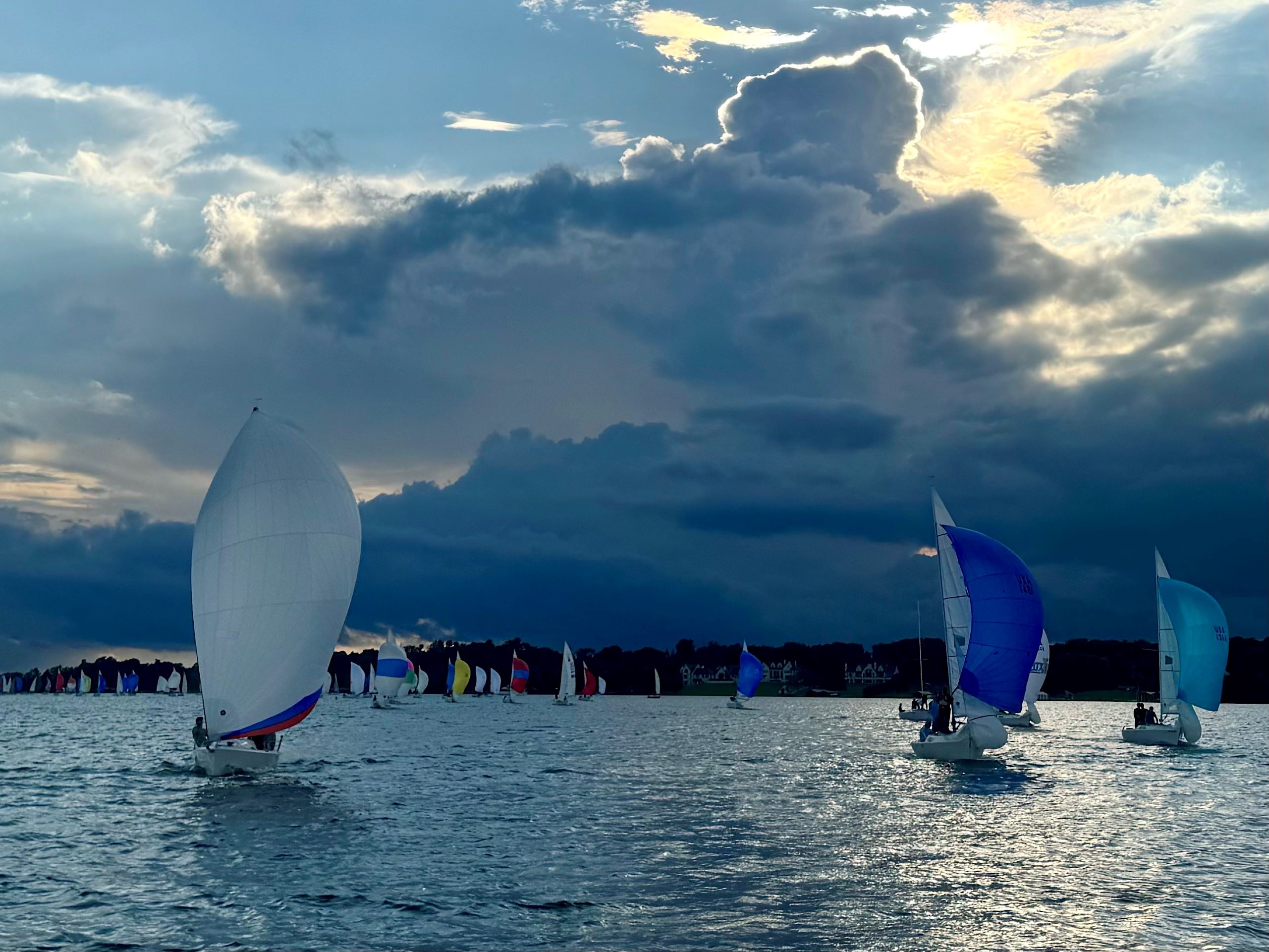 lake Minnetonka with several sailboats and a cloudy sky with sunshine breaking through